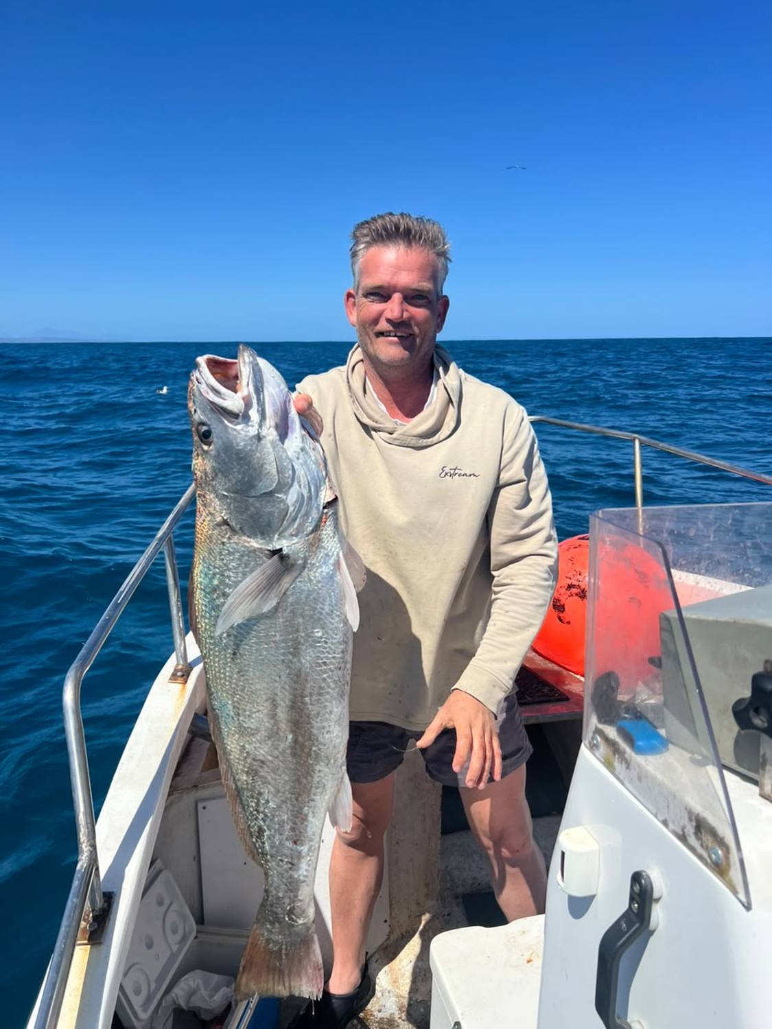 Angler on board with a large Cape salmon caught off Gansbaai